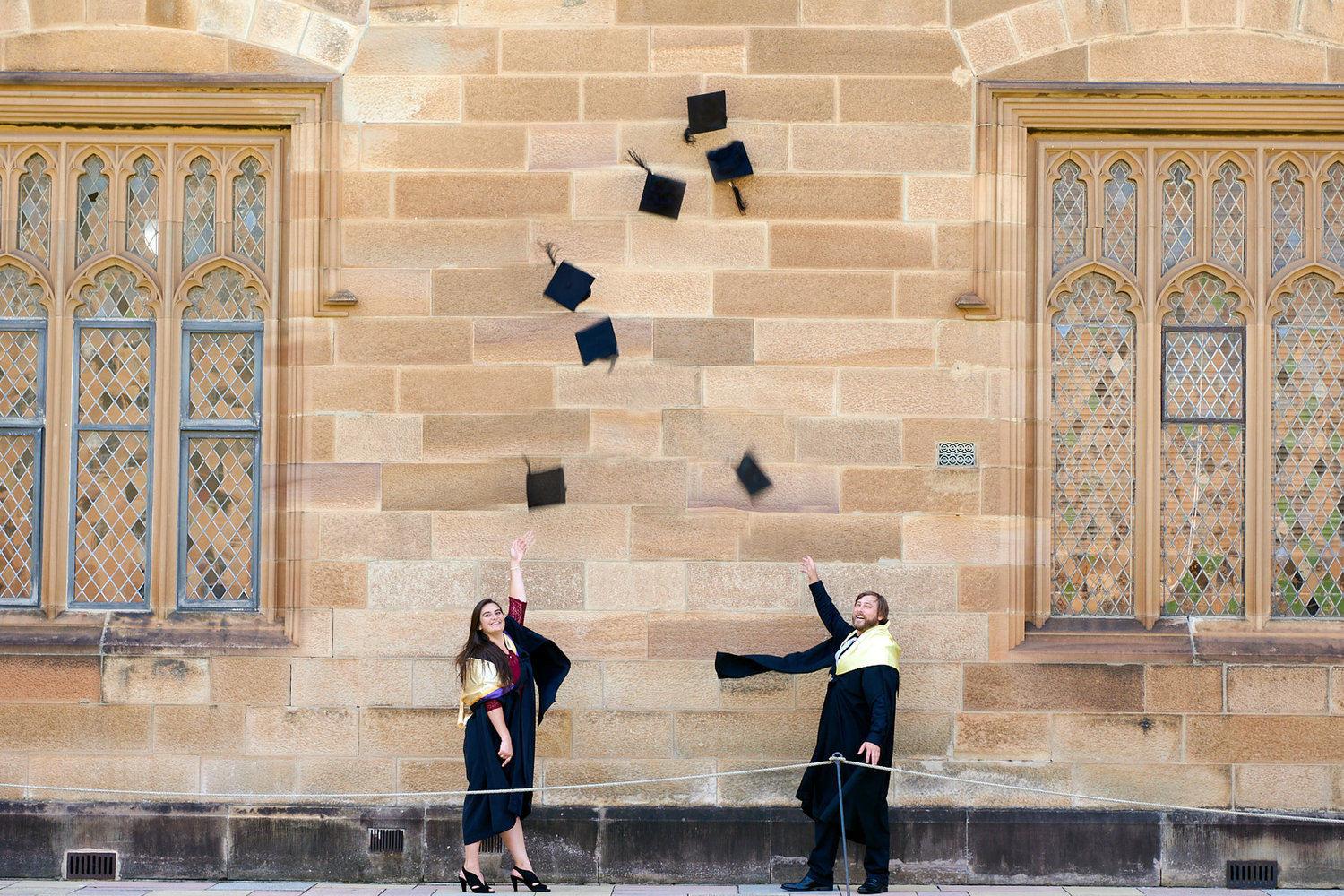 Graduation photo at Sydney University usyd Quadrangle. Cap throwing