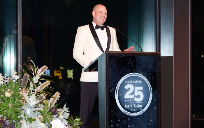 Corporate Event Photo, Podium, Microphone, Lectern, Spokesperson, Formal Wear, White Black Tie Suit. Photography By orlandosydney.com