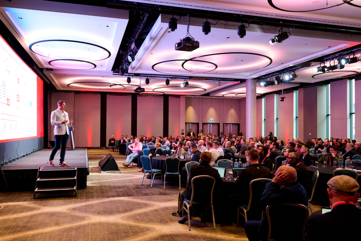 Speaker on stage with large audience in the room at an Events at Sofitel Sydney Darling Harbour Speaker on stage with large audience in the room at an Events at Sofitel Sydney Darling Harbour